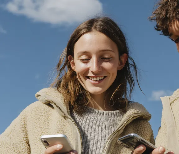 Two people looking at a phone outdoors