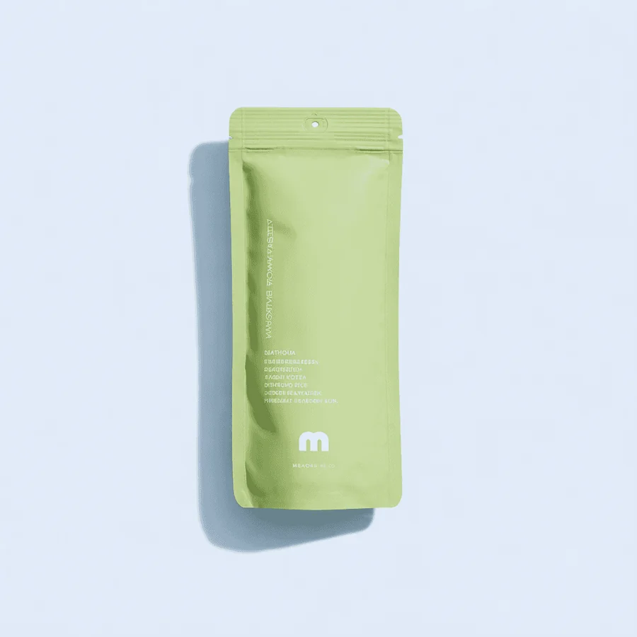 A pale green matcha sachet on a light blue background