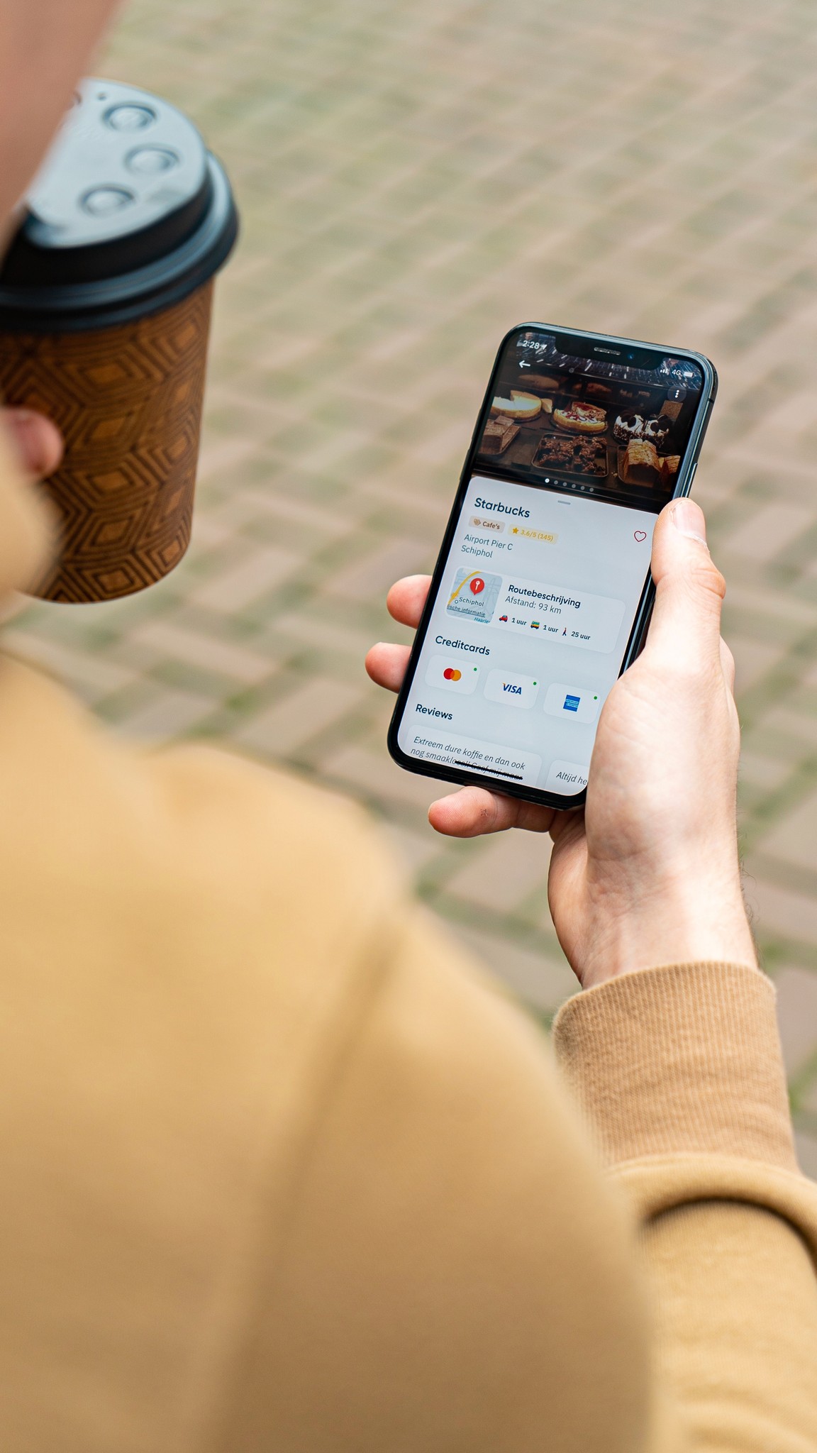 Person holding a phone showing the Pluma app